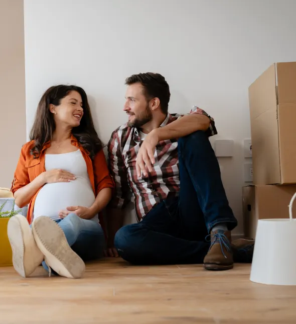 Happy Couple Sitting On The Floor In The New Home