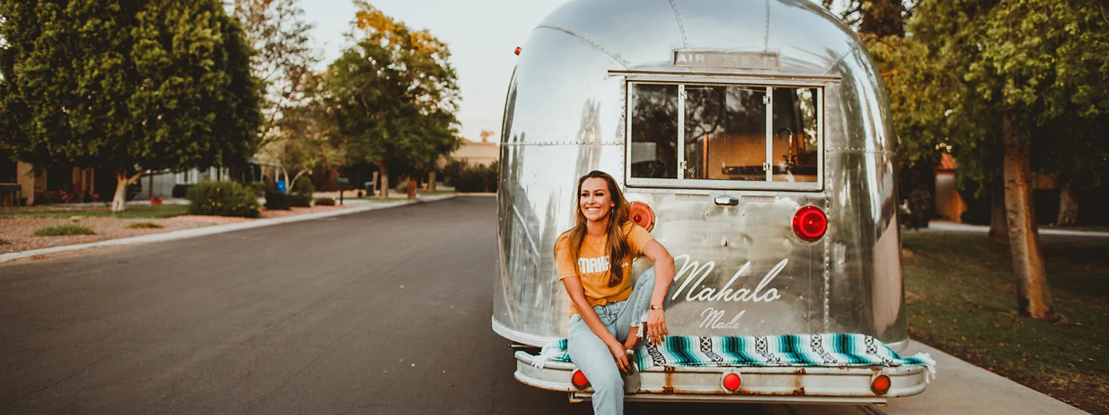 Lady La Sitting On Back Of Mahalo Made Airstream 1600X600